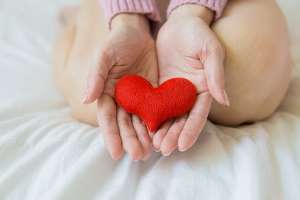 Photo of hands holding red felt heart