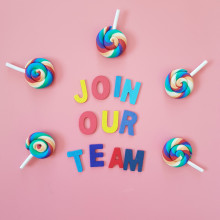 Colourful lollipops in a circle with words Join our team in the middle, on a pink background.